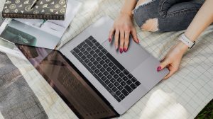 crop college student using laptop in park